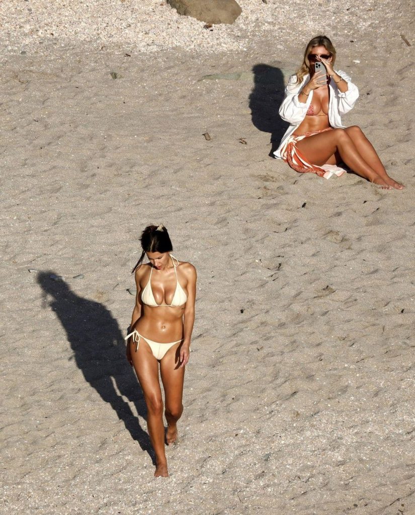 Natasha Oakley snapping photos of Devin Brugman in a white bikini