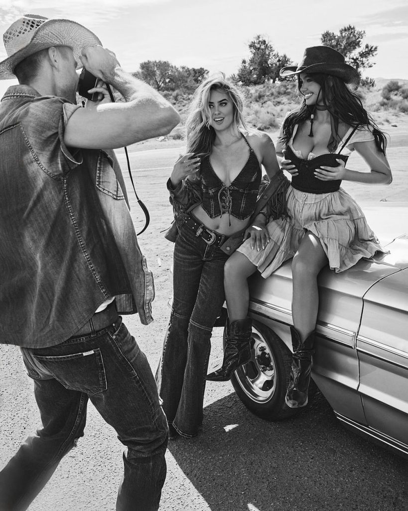 Cow boy snapping photos of two cow girls