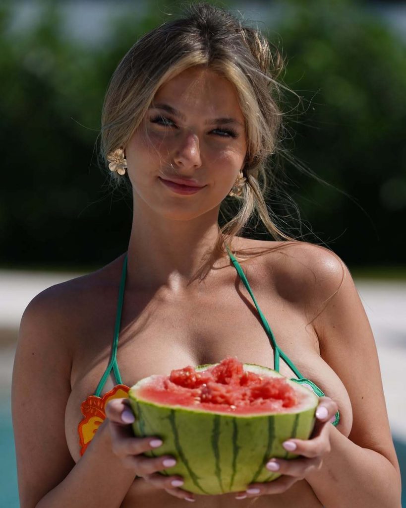 Grace Boor holding up a melon by the pool