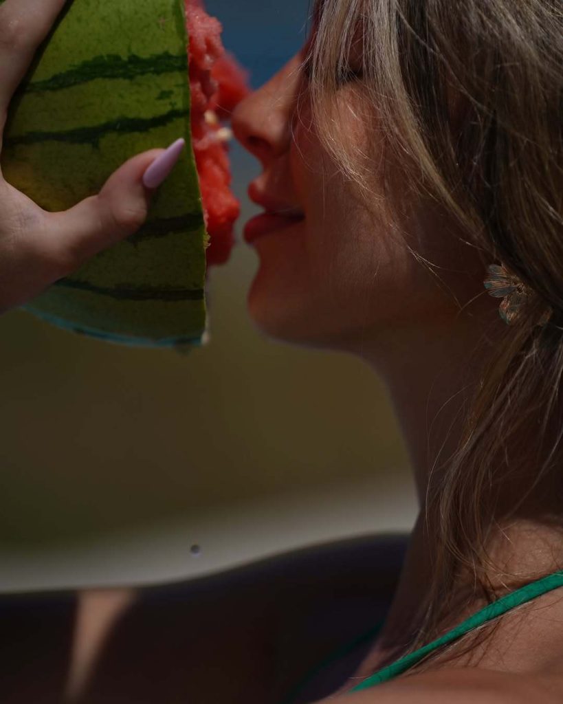 Close up of girl putting melon to her face